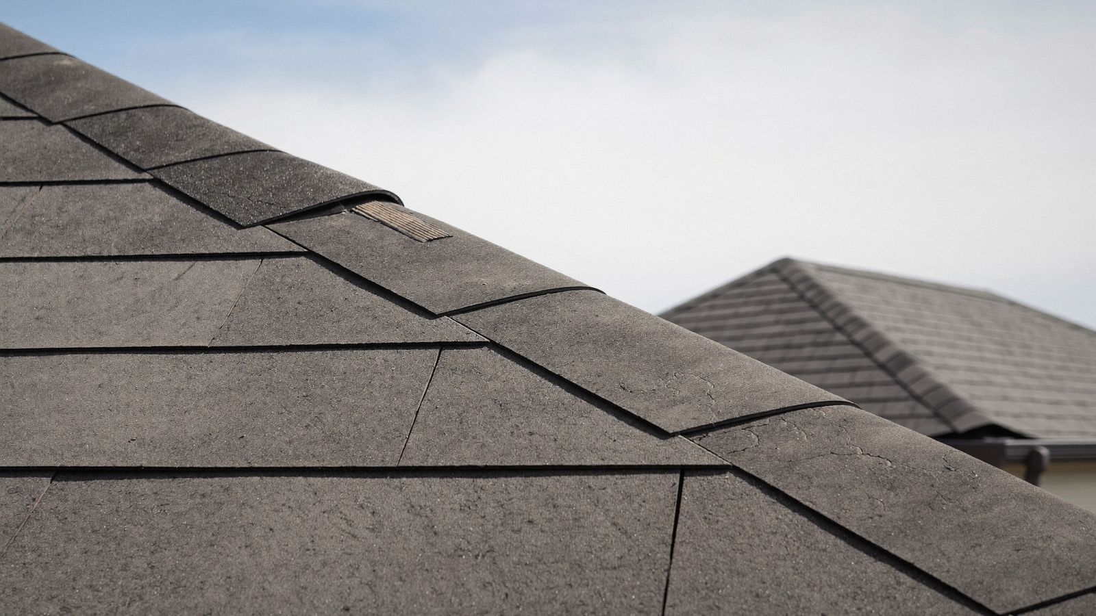 Aging asphalt shingle roof with cracked and worn shingles on a Gulf Coast Texas home