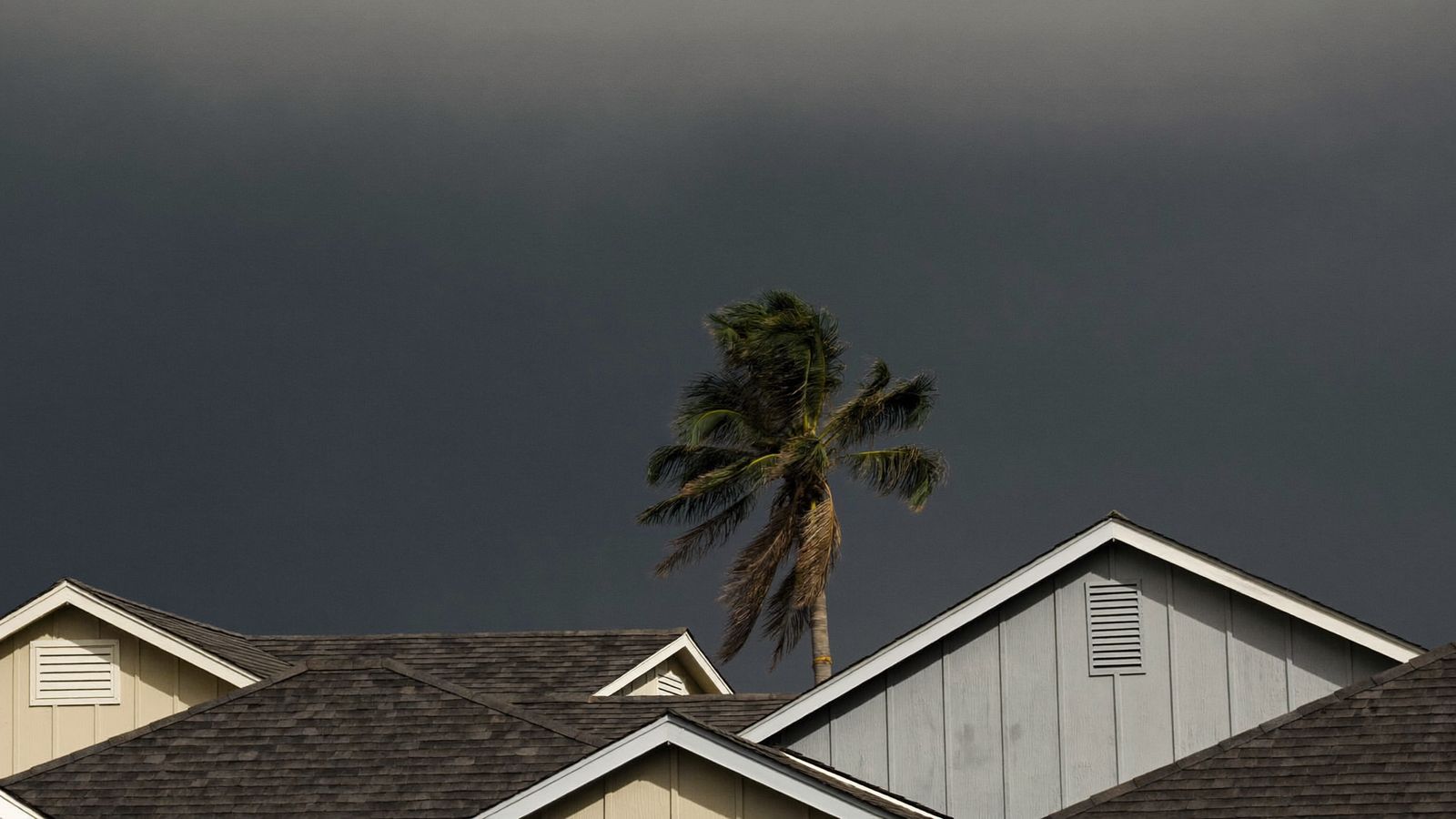 Dark hurricane storm front rolling in over Gulf Coast rooftops